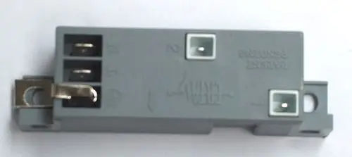 Graues Gehäuse mit Anschlüssen und einer metallischen Sicherung. Produkt von Daikin, wahrscheinlich Bestandteil eines Zündsystems.